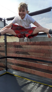 Gymnasts in action wearing tartan culottes as part of their school uniform